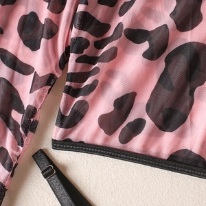 Detailed macro shot of pink leopard print sheer mesh fabric with black elastic trim