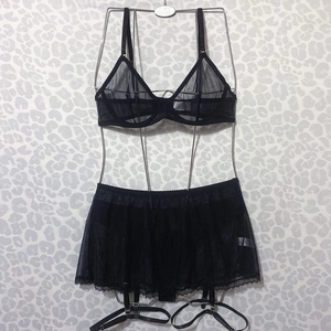 Detail of black sheer mesh lingerie set featuring lace trim and garter belt details