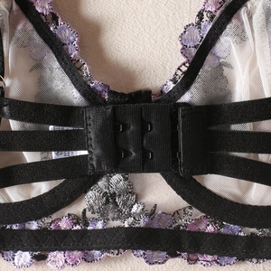 Détail de la fermeture à double agrafes au dos avec broderie florale violette et dentelle
