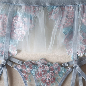 Close-up of light blue mesh lingerie set with floral embroidery and adjustable buckles