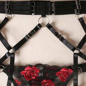 Détail macro de broderie florale sexy sur dentelle noire avec anneaux en métal