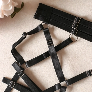 Gros plan détaillé de sangles de jambe élastiques noires réglables avec anneaux en métal