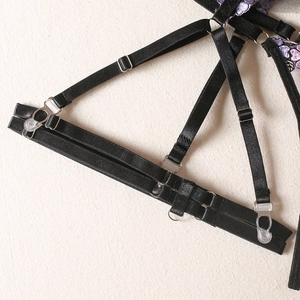 Détail de jarretelles réglables avec broderie florale violette et boucles métalliques