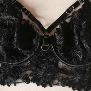 Close-up of black lace embroidery bra with silver O-rings and adjustable straps