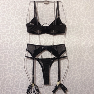 Three-piece black lace lingerie set with polka dot mesh, garter belt and thong detail