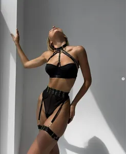 Detail of black strappy lingerie set with gold metal adjusters and cutout mesh design
