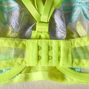 Detailed macro view of neon green sheer mesh floral embroidery with back hook closure