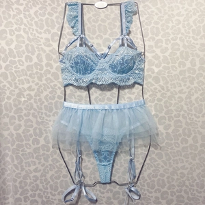Detail of light blue lace lingerie set featuring intricate floral ruffles and sheer mesh skirt