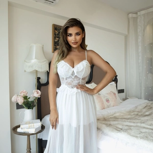 Detail of white lace bodice with floral patterns and sheer mesh skirt on long nightdress