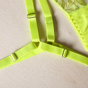 Detail of neon green embroidery and adjustable elastic straps on sexy mesh lingerie