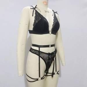 Détail d'ensemble de lingerie en dentelle noire avec anneau cœur doré et nœuds sur soutien-gorge