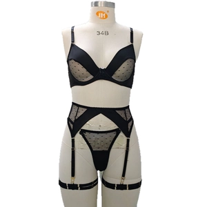 Three-piece black polka dot mesh lingerie set with bra, garter belt and thong on mannequin