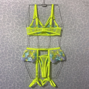 Detail view of neon yellow lace lingerie with multi-color floral embroidery and sheer mesh