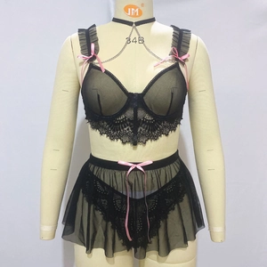 Detail of black sheer lace bra with pink ribbons and delicate mesh mini skirt set