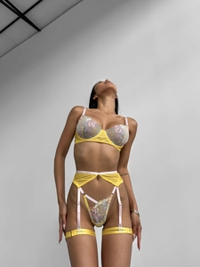 Detail shot of sheer yellow mesh lingerie set with intricate floral embroidery details