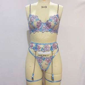 Détail de la broderie florale et des chaînes sur la lingerie en dentelle bleu clair