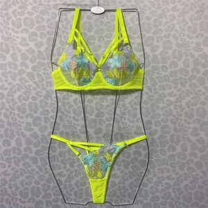 Detail of neon yellow mesh lingerie set featuring colorful floral embroidery on bra and thong