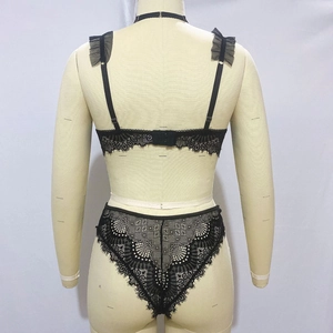 Detailed back view of black lace lingerie set with mesh ruffles and metal clasp closures
