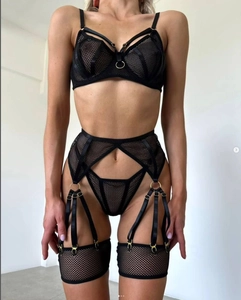 Detail of black mesh lingerie set featuring metal ring accents and hollow-out lace design
