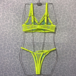 Detail of neon green mesh bra featuring intricate floral embroidery and multi-strap design