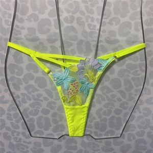 Close-up of neon yellow G-string featuring delicate floral embroidery and thin elastic straps
