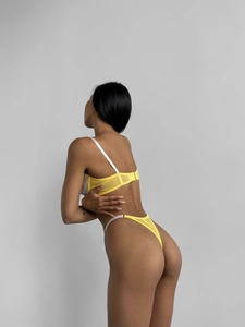 Detail view of bright yellow floral embroidery lace bra and matching thong on model