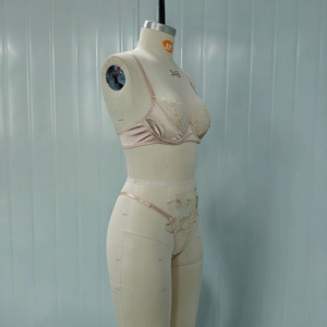 Detail of champagne gold satin lingerie set with floral embroidery and lace on mannequin