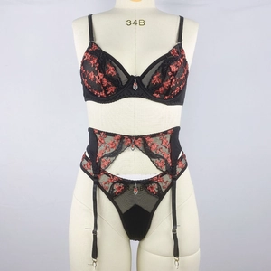 Détails de broderie florale rouge sur lingerie en dentelle noire avec pendentif rubis