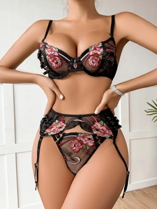 Close-up of intricate red floral embroidery on sheer black mesh lace lingerie set