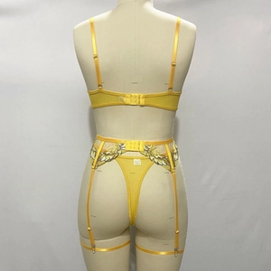 Detail of yellow embroidery on the back of a 3-piece sexy lingerie set with thong