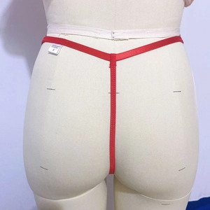 Detail eines roten bestickten Spitzen-Strings mit Materialetikett und S-Größe