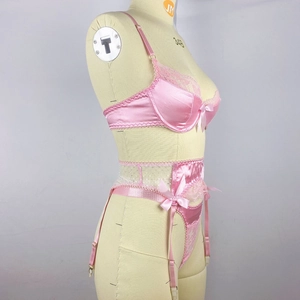 Detail of pink satin lingerie set with lace stitching and small bow decorations