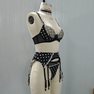 Detail view of black polka dot sheer mesh lingerie set with lace trim and garter on mannequin