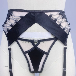 Detail view of black velvet lingerie with silver metal chains and crisscross straps