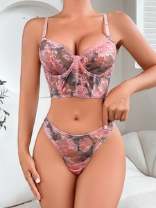 Detailed view of pink floral lace fabric and delicate embroidery on the corset bra set