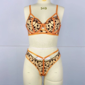 Détail d'un ensemble de lingerie orange avec broderie de vigne délicate sur le soutien-gorge