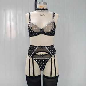 Detail of black polka dot lingerie set with lace trim and bow accents on a mannequin