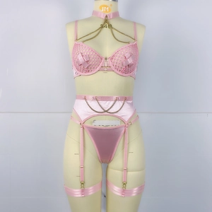 Détail d'ensemble de lingerie rose avec chaînes, soutien-gorge en maille et jarretelles