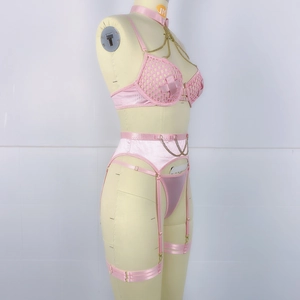 Détail d'un ensemble de lingerie rose avec chaînes en métal et tissu en maille