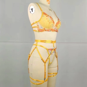 Detail of yellow floral embroidery and satin texture on the sexy lingerie set with garters