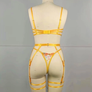 Detail of yellow lingerie set featuring floral embroidery and complex strap design