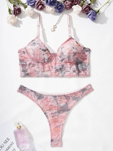 Detail of floral lace lingerie set with pearl heart pendant and matching thong