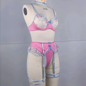 Detailed embroidery on pink lace bra with garter belt and blue leg strap details