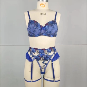 Détails de broderie florale bleue sur l'ensemble de lingerie avec porte-jarretelles