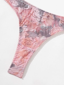 Close-up of floral lace lingerie showing pink rose patterns and delicate scalloped edges