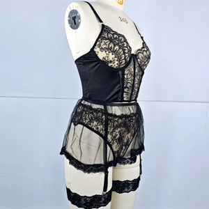 Black floral lace four-piece lingerie set with sheer mesh suspenders on a mannequin