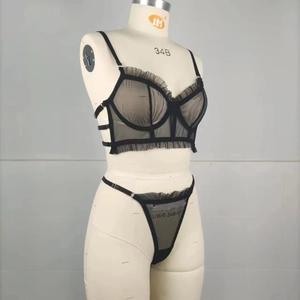 Detail view of sheer black mesh lingerie set with lace trim on a lingerie mannequin