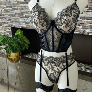 Lace lingerie set with sheer black embroidery, corset bodice, and garter straps
