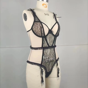 Detail of black lace bodysuit featuring floral patterns, ruffles, and adjustable garters
