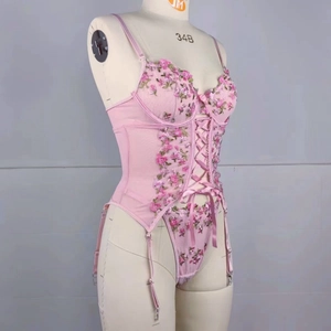 Détail de la broderie florale rose et du laçage sur ce body en tulle transparent